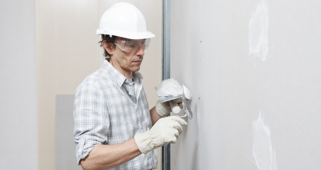 stock-photo-man-drywall-worker-or-plasterer-putting-plaster-on-plasterboard-wall-using-a-trowel-and-a-spatula-1921959587-transformed