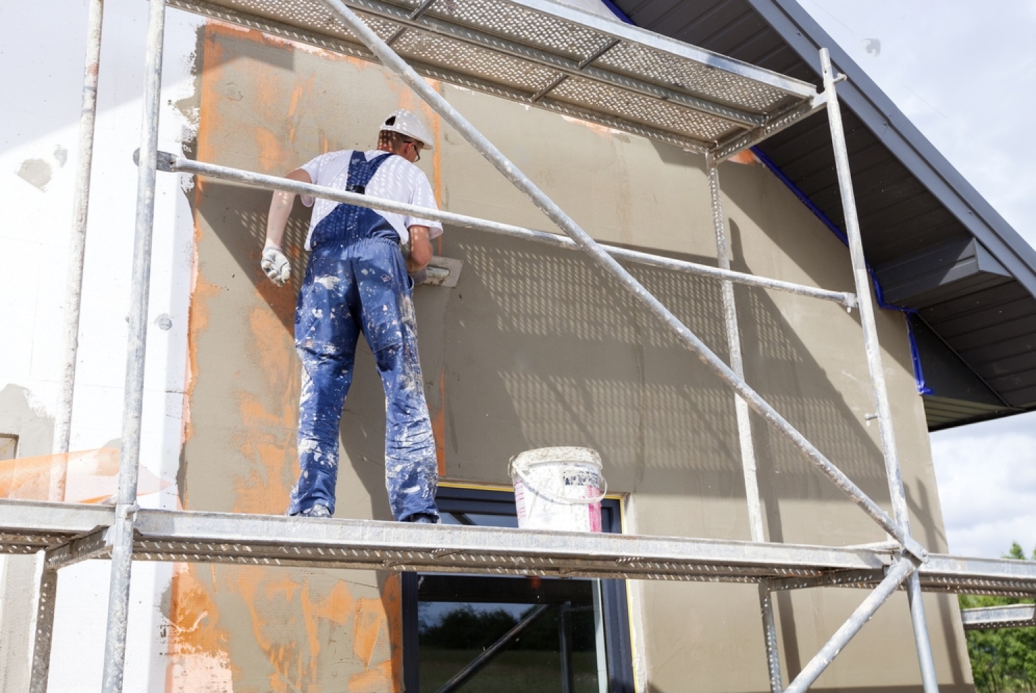 stock-photo-worker-spreading-mortar-over-styrofoam-insulation-and-mesh-with-trowel-437667442-transformed